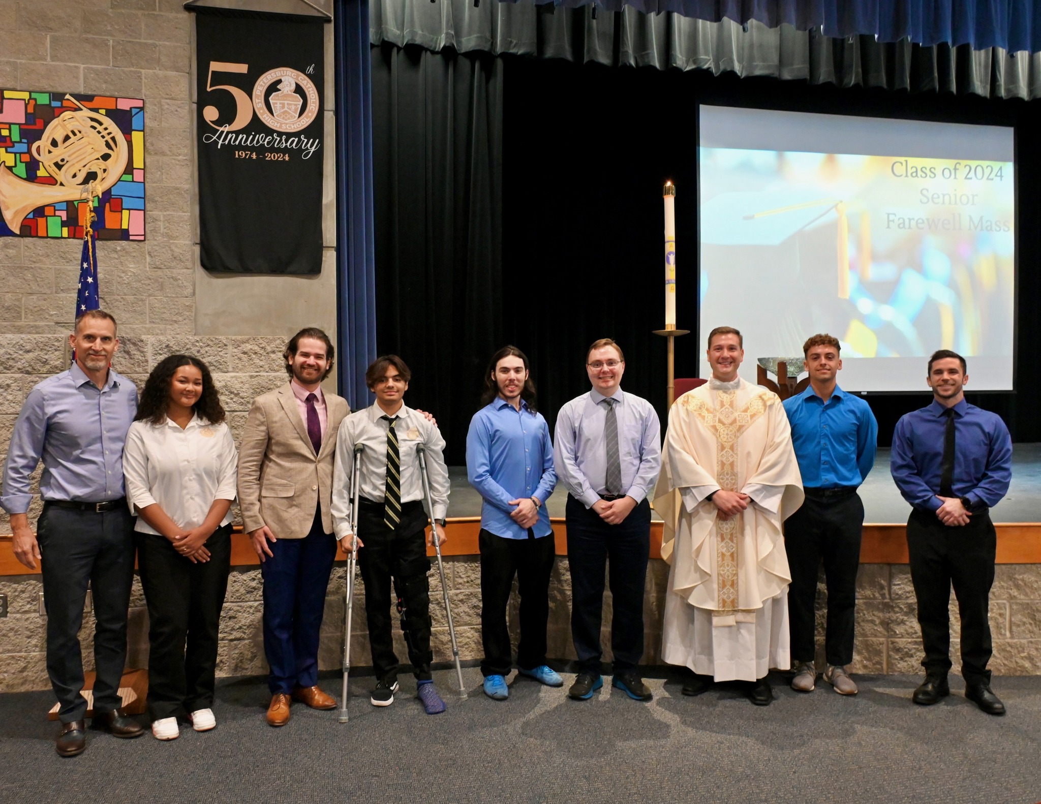The newly confirmed students and teacher stand with Fr. Ralph D’Elia and their confirmation sponsors after the conclusion of the Mass. | Photo from St. Petersburg Catholic High School.