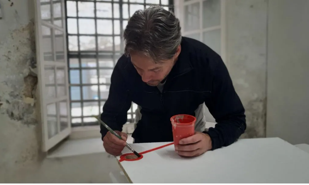 Pedro Silva puts the finishing touches on painting a confessional.