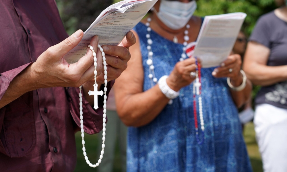 People hold rosaries while participating in a roadside prayer rally marking Religious Freedom Week at St. James Church in Setauket, N.Y., | Photo by OSV News /CNS file, Gregory A. Shemitz
