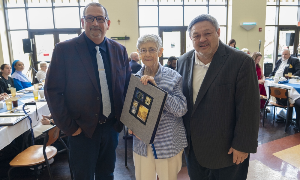 Town of St. Leo Mayor Mike D'Ambrosio, Sister Roberta Bailey, and Saint Leo University President Ed Dadez with scrapbook presented to Sister Roberta with wishes from students, faculty, and staff.