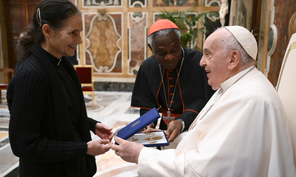 Rev. Sabina Alkire, a scholar of the Pontifical Academy of Social Sciences, gives Pope Francis a gift during a meeting for the academy's plenary session at the Vatican April 11, 2024. Cardinal Peter Turkson, Cardinal Peter Turkson, chancellor of the academy, is seen at center. | Photo by CNS photo/Vatican Media.