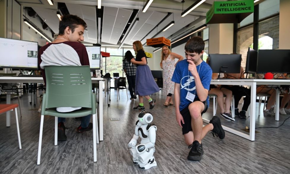 Logan Carbonaro and Logan Koschman work with their robot in 2023