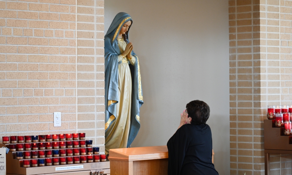 A woman prays in front of a statue of the Blessed Virgin Mary during the sixth annual Marian Congress. | Photo by Brittany DeHaan.