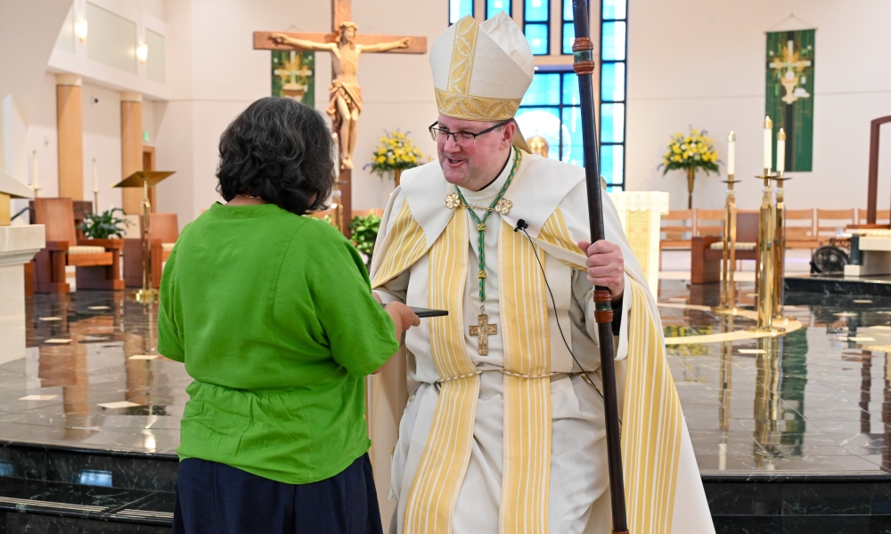 Bishop Gregory Parkes presents a certificate to one of the LPMI graduates. | Photo by Brittany DeHaan.