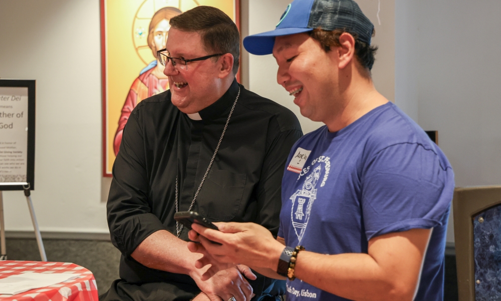 An event guest shares a video with Bishop Gregory Parkes.