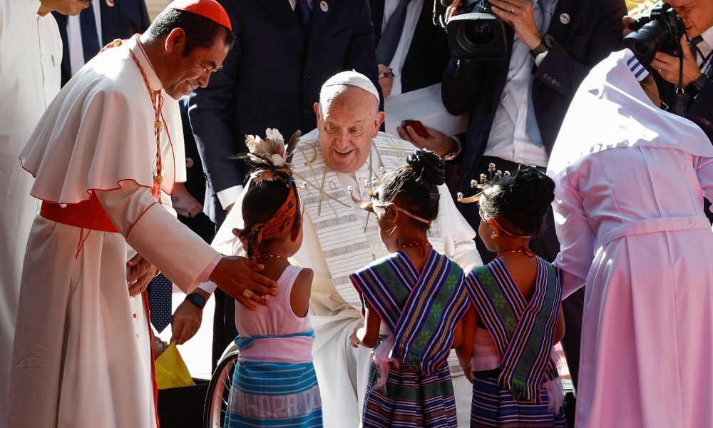 Pope Francis greets children in traditional dress during a visit with children who are seriously ill or have severe disabilities at the Irmas Alma School in Dili, Timor-Leste, Sept. 10, 2024. He is joined by Cardinal Virgílio do Carmo da Silva of Dili. | Photo by CNS/Lola Gomez.