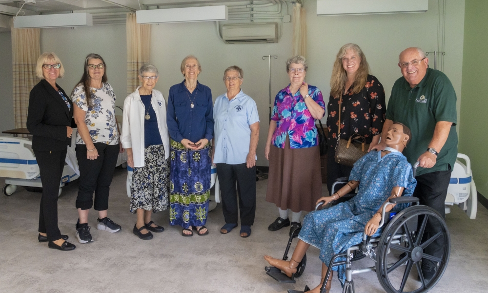 Dr. Kathleen Van Eerden, Benedictine Sisters, Volunteers, and Father John McEvoy in the skills lab. | Photo by Marie Thornsberry, Saint Leo University.