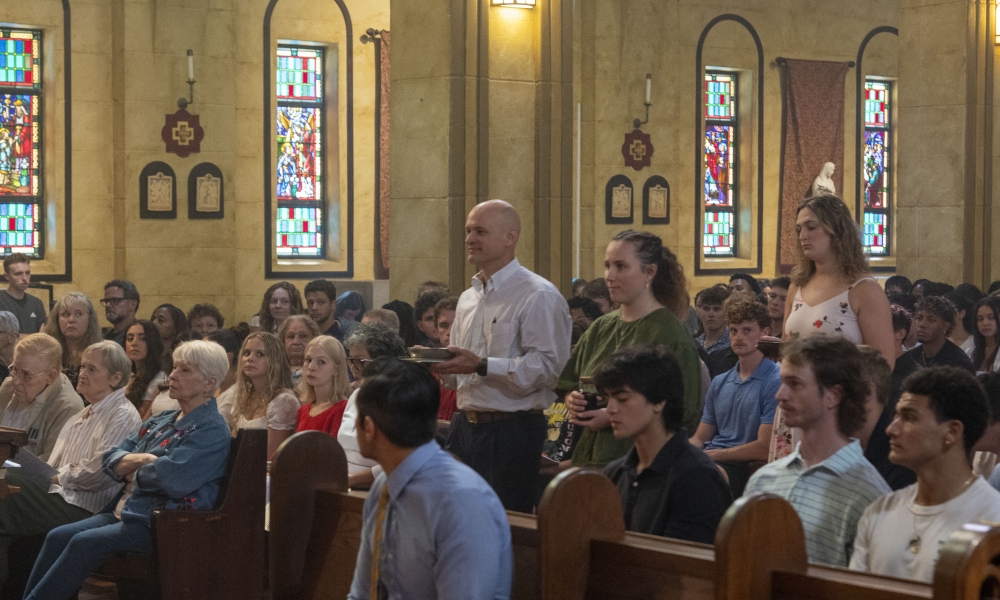Dr. Tommy Humphries and students Cara Charron and Clare Daley bring forth the Eucharistic gifts. | Photo by Caroline Jorgensen, Saint Leo University