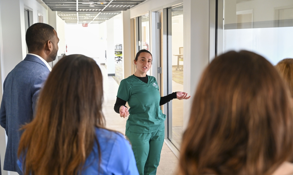 Bella Romeo, a junior nursing student, gives Saint Leo University trustees, donors, Pasco County commissioners, health care representatives, and other guests a tour of the nursing floor in Benedictine Hall.
