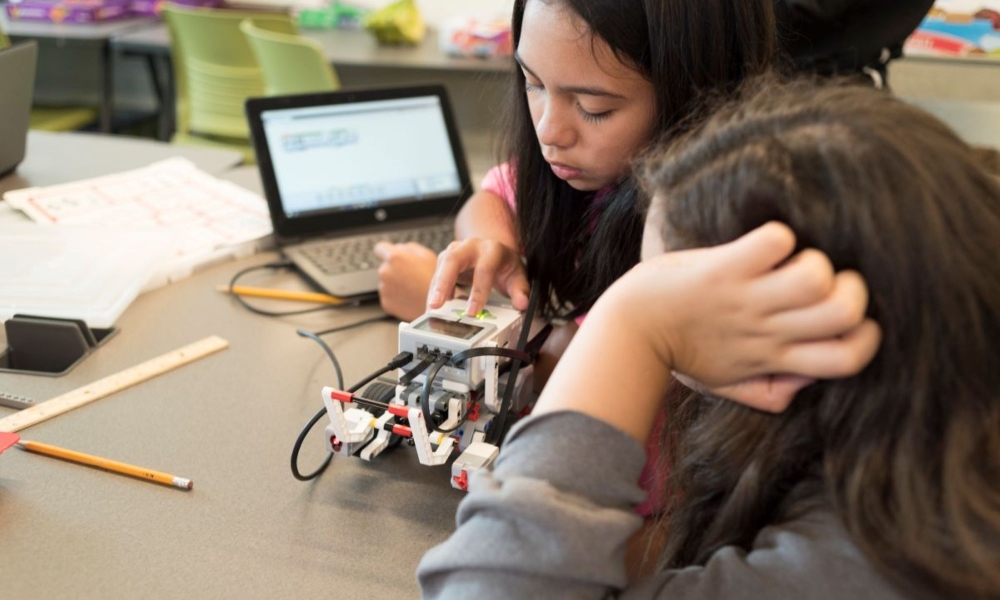 two girls work on robots