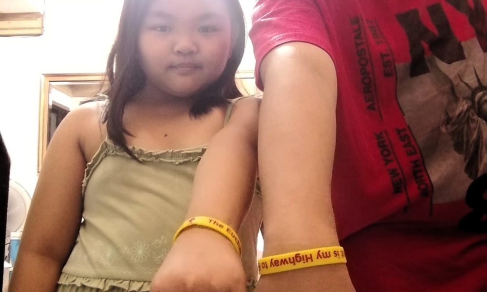 Children in the Philippines show their bracelets.