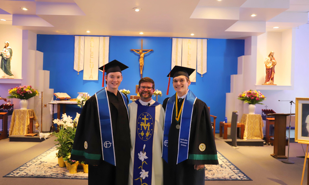 Father Kyle Bell (center) takes a photo with graduates Daniel Jordan (left) and Joseph Levesque (right). | Courtesy photo.