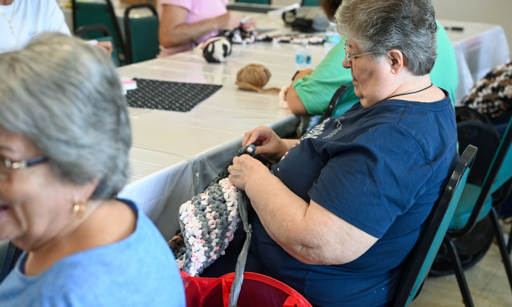 Volunteers work on crocheting mats for the homeless. | Photo by Brittany DeHaan.