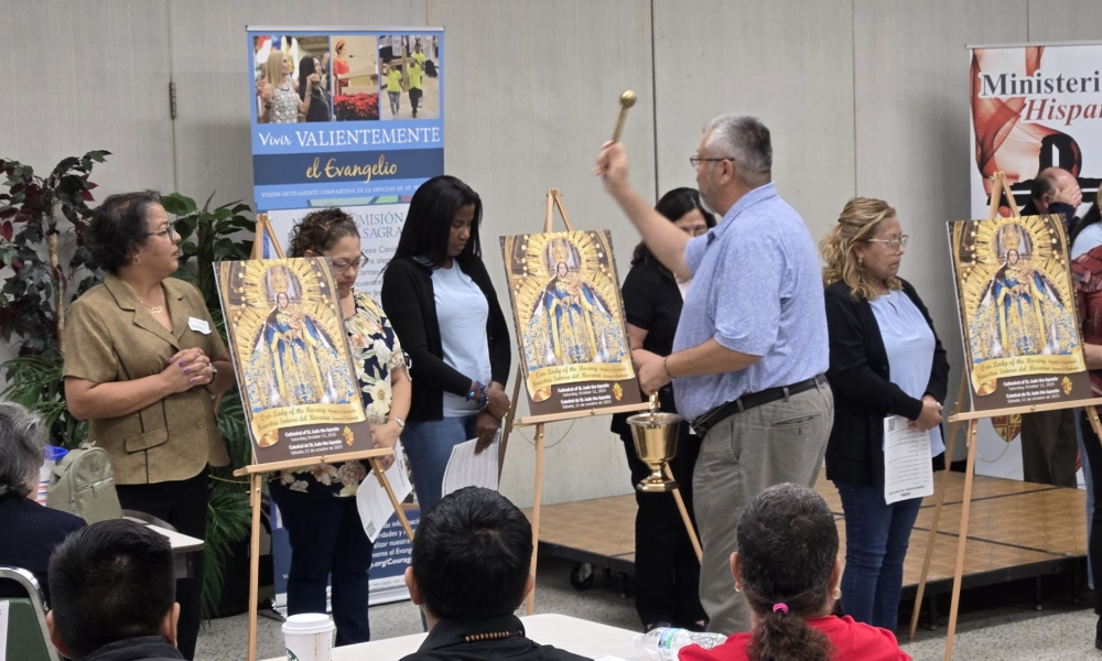 Participants and images of the Blessed Mother are blessed at the Hispanic Assembly meeting.