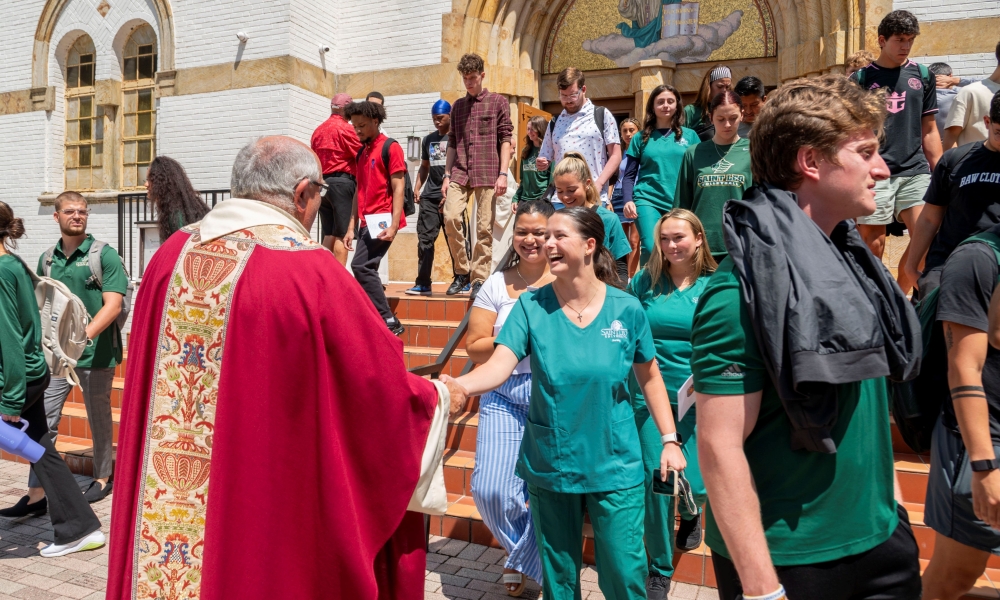 Father John McEvoy greeting students after Mass. | Photo by Caroline Jorgensen, Saint Leo University.