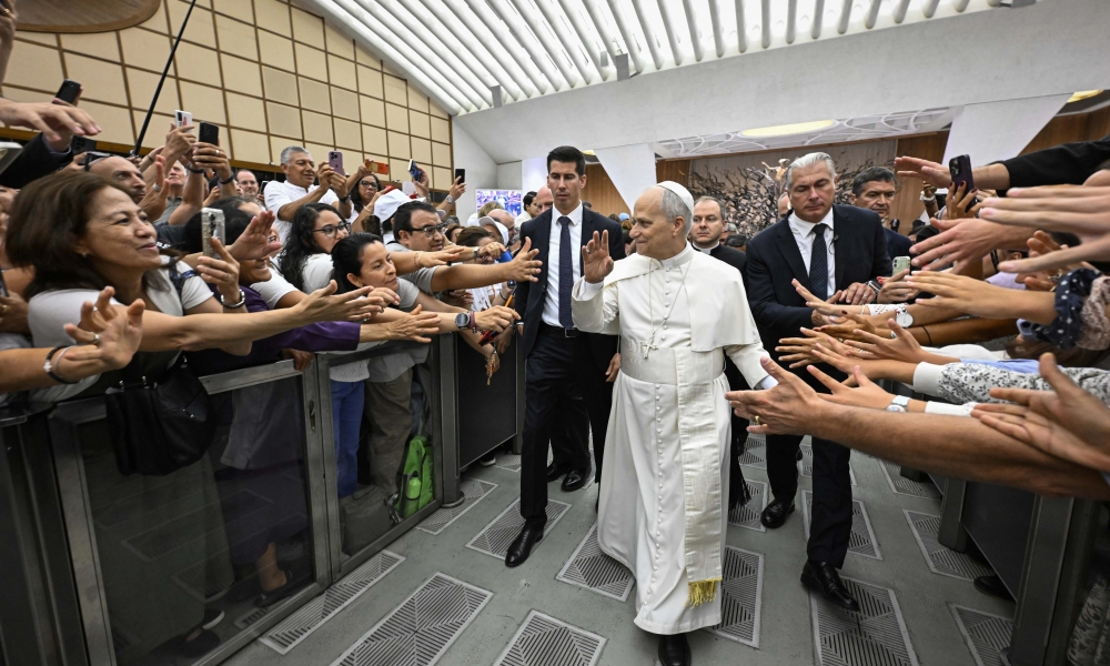 Pilgrims reach out to Pope Leo XIV at the general audience in the Paul VI Audience Hall, Vatican City, Wednesday, Aug. 27, 2025.