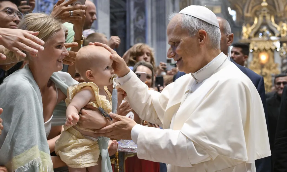 Pope Leo XIV blesses a baby during his Wednesday general audience in St. Peter’s Basilica on Aug. 13, 2025, at the Vatican.