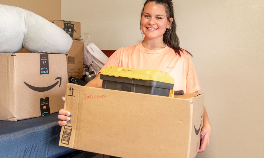 Pre-nursing student Silvana Mazzola moves a box of her belongings into her residence hall room. She is part of the Nursing Living Learning Community.