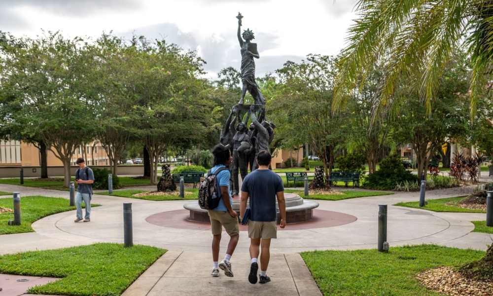 Students walk by the For Those Who Serve sculpture that honors Saint Leo University’s longstanding commitment to providing educational opportunities to servicemembers and veterans.