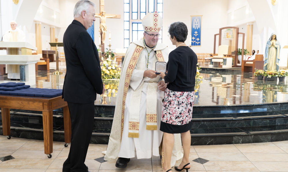 Bishop Gregory Parkes awards a recipient with the St. Jude the Apostle medal.