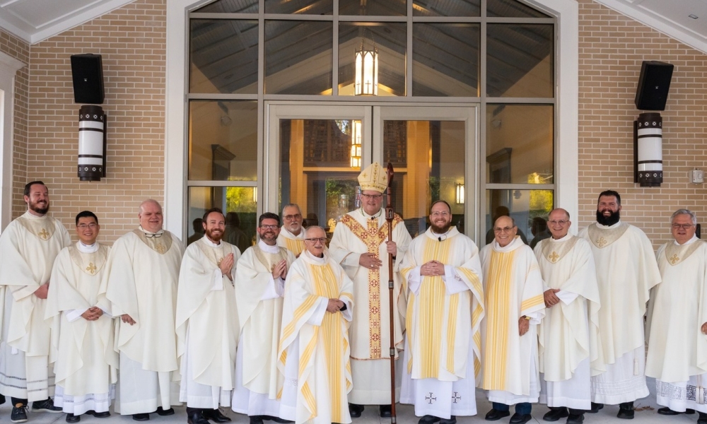 Father Jonathan Stephanz takes a photo with his fellow priests and Bishop Gregory Parkes following his installation as pastor.