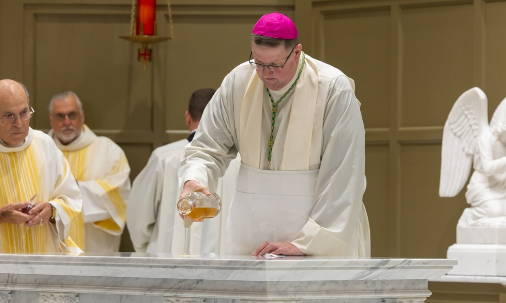 Bishop Gregory Parkes pours chrism oil on the new altar.