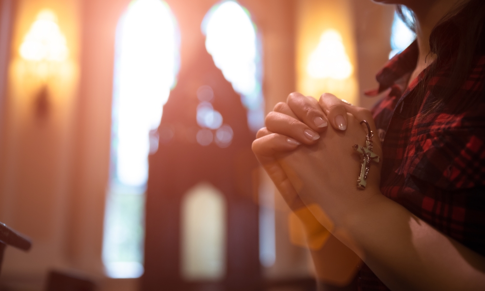 Person praying with rosary