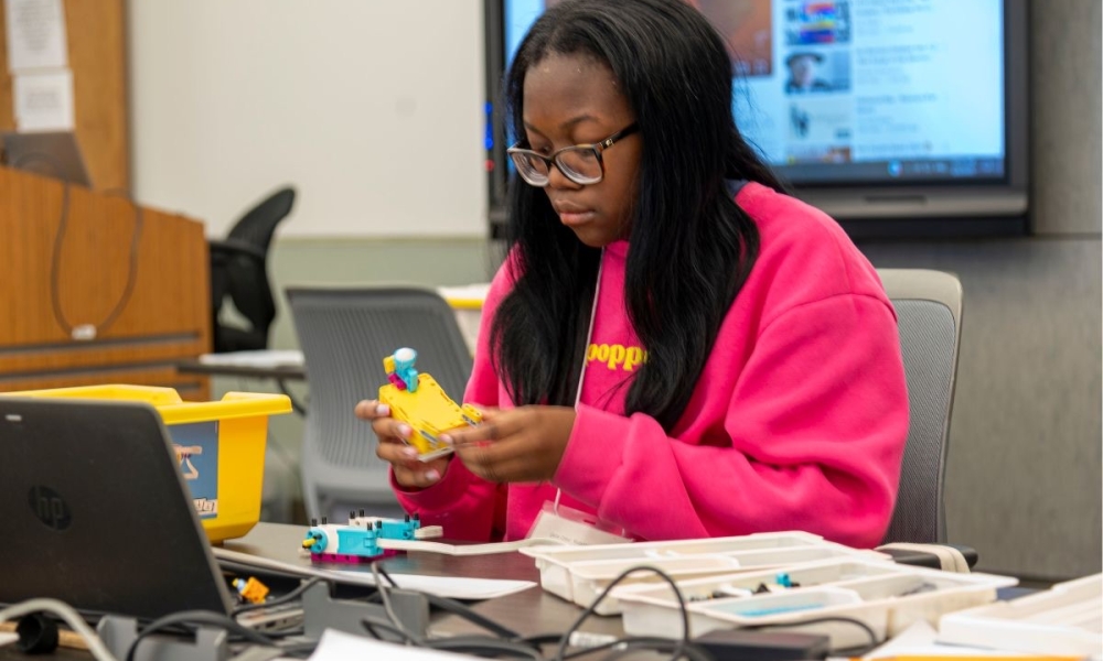 A Girls Can! robotics camper builds a robot.