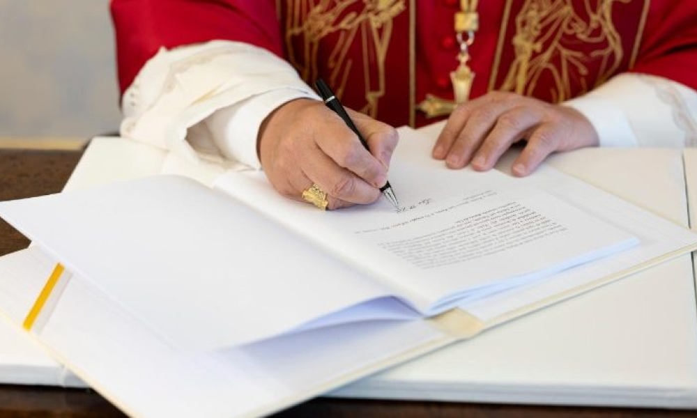 Pope Leo XIV signing his Encyclical Letter "Magnifica humanitas"  (@Vatican Media)