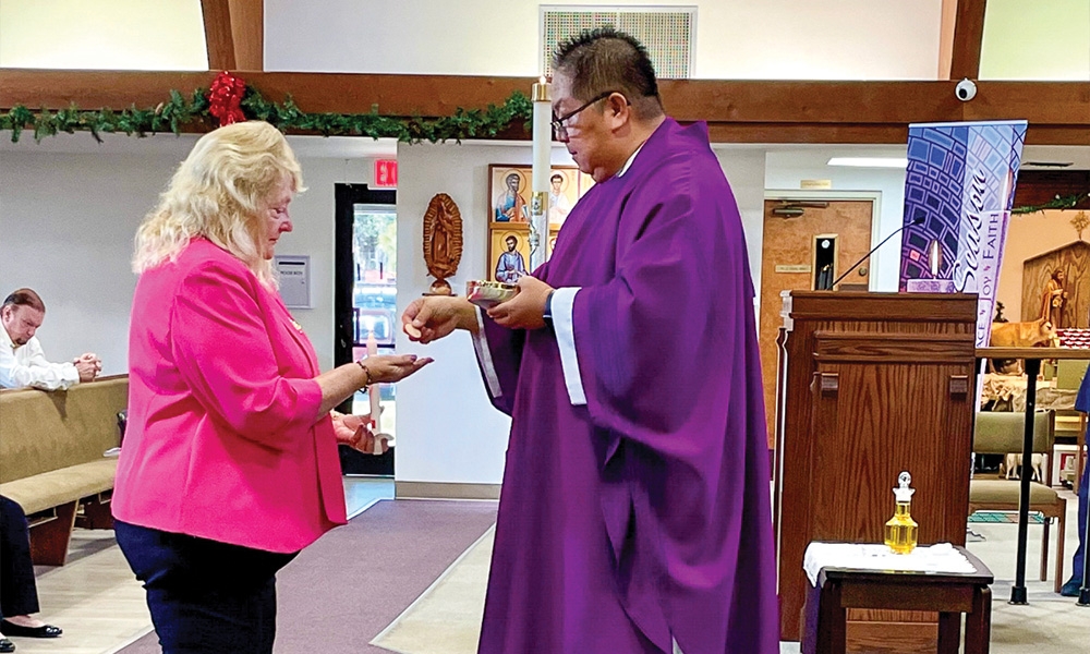 Jane Prefer receives the Eucharist from Father Glenn Diaz at St. Thomas the Apostle Catholic Church