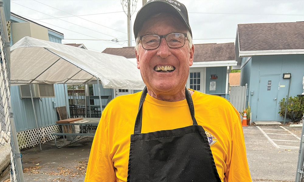 Richard Buzzee, Knights of Columbus volunteer, serves a pan of freshly fried fish at the Lenten Fish Fry hosted by Our Lady of the Rosary Catholic Church, March 2024