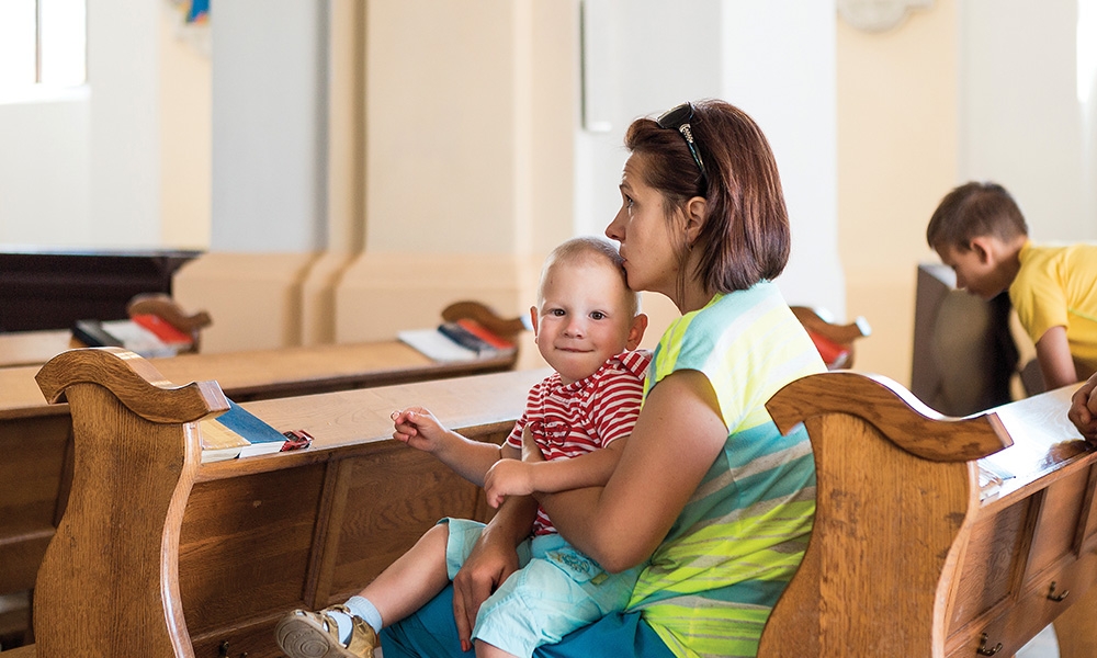 Mother holding child in pew