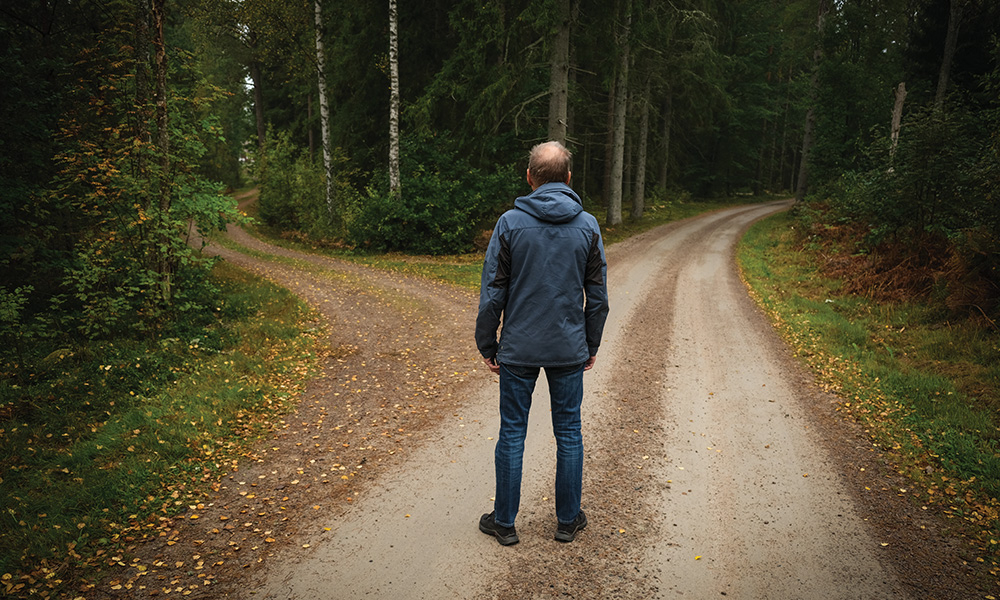 Man standing at a fork in the road